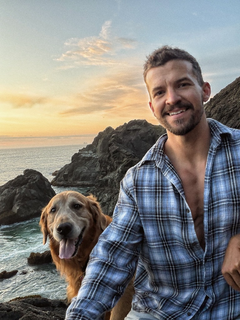 Taylor and Scout on a rocky coast at sunset